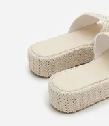 Sandalia flatform con superficie trenzada metalizada color dorado, sin cierre, con tira ancha y puntera redonda.