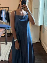 Vestido largo de denim azul, con tirantes anchos, escote recto y aberturas laterales en la falda.