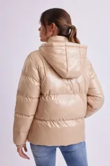 Campera puffer color beige de poliéster con capucha, cierre frontal con cremallera y bolsillos laterales.