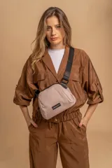 Bandolera pequeña de tela negra, con correa ancha ajustable y cierre superior.