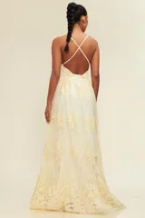 Vestido largo color crema con breteles finos, escote en V pronunciado y falda de tul con bordado floral.