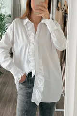 Camisa blanca de manga larga con volados en el frente y en los puños.