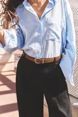 Pantalón blanco de lino, de tiro alto con pinzas delanteras, bolsillos frontales y falsos bolsillos con solapa en la espalda. Incluye cinturón marrón.