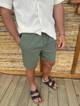 Bermuda de corte recto color verde militar, con cintura elastizada y cordón ajustable.