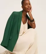 Vestido midi de color negro confeccionado en tejido de viscolino. Cuenta con breteles finos, escote redondo con pliegues frontales y un panel con volado en el ruedo.