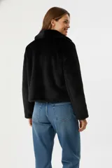 Chaqueta corta negra de piel sintética con cuello clásico, cierre frontal con cremallera y mangas largas.