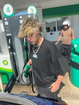 Remera marrón de corte holgado con estampado en la espalda que incluye la palabra 'Ibiza' y la frase 'It Itai' sobre bloques de hielo.