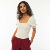 Blusa crop color blanco con escote cuadrado, mangas cortas abullonadas y cuerpo elastizado.