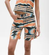Bermuda de denim con estampado abstracto en tonos naranja, celeste y negro.