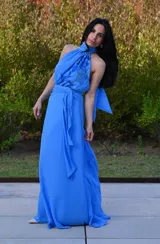 Vestido largo celeste de gasa con estampado floral en el corpiño, cuello halter y lazo en la cintura.