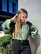 Blusa verde con escote cuadrado y mangas abullonadas.