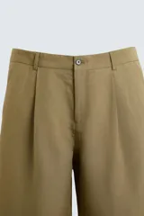 Pantalón color caqui de corte amplio, confeccionado en tejido de lyocell y lino. Presenta pliegues frontales, bolsillos laterales y traseros de ojal. Cierre frontal con cremallera y botón.