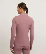 Campera deportiva negra de manga larga y cuello alto, con cierre frontal. Presenta recortes en el torso y bolsillos laterales con cierre.