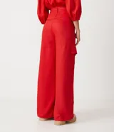 Conjunto de top corto con escote en V y mangas abullonadas, y pantalón palazzo con bolsillos cargo y lazo en la cintura, ambos en color rojo.