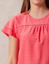 Blusa blanca de tejido pointelle con manga corta con volados y cuello redondo.