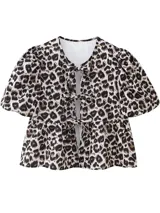 Blusa con estampado animal print, con escote en V y lazos decorativos. Tiene mangas cortas abullonadas y corte peplum.