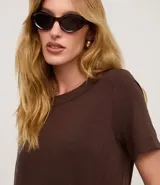 Vestido corto de mujer, estilo camiseta, color terracota/óxido, con escote redondo, mangas cortas y bolsillos laterales. El bajo es redondeado.