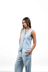 Chaleco celeste de lino con cuello en V y cierre frontal con botones.