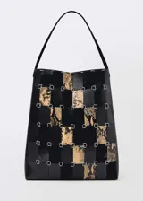 Bolso tipo shopper con estampado animal print, confeccionado con piezas de cuero bovino, ovino y caprino unidas con anillas metálicas.