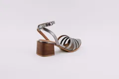 Sandalias doradas de cuero sintético con tiras de tela transparente y tacón de madera.