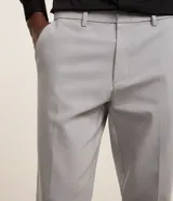 Pantalón de vestir de corte slim, color gris claro, con cintura con trabillas, cierre tradicional, bolsillos laterales y traseros. Confeccionado en algodón, poliéster y elastano.