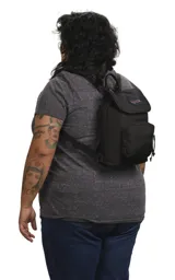 Mochila mini de poliéster color negro con logo JanSport en el frente, asa de mano y bolsillo frontal con cierre.