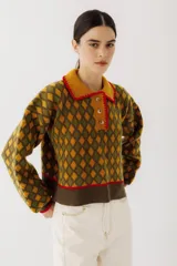 Buzo de lana color beige con diseño de rombos marrones, cuello polo con botones y detalles bordados.