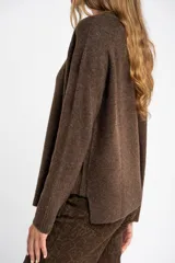 Sweater color marrón claro de tejido de punto, con cuello redondo y mangas largas.