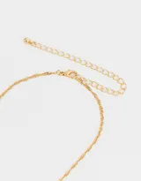 Cadena dorada con dije de strass y corazón de metal.