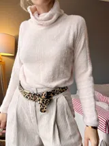 Sweater de cuello alto color beige, de tejido suave y mangas largas.