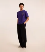Remera masculina de algodón color violeta, corte comfort, cuello redondo y manga corta. Estampa con dos caras sonrientes en el lateral izquierdo del pecho.