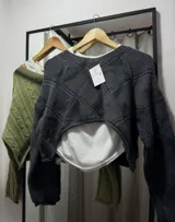 Sweater tejido de punto color crema, con cuello redondo y mangas largas.
