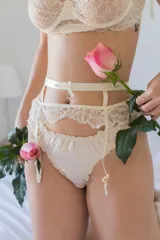 Portaligas de encaje color crema con detalles en la cintura, diseñado para un ajuste delicado y cómodo.