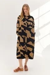 Vestido midi color camel con estampado geométrico y manga larga, con botones frontales y cinturón a juego.