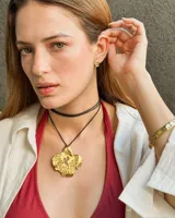 Set de dos piezas de joyería para la oreja: un arete de botón con forma orgánica irregular y un ear cuff a juego, ambos de metal dorado con acabado martillado.