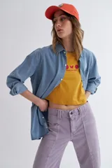 Camisa celeste de jean de manga larga con cuello clásico y cierre frontal con botones.