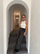 Pantalón de jean negro con tachas plateadas en forma de corazón.