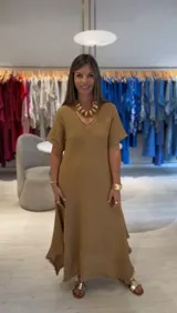 Vestido largo color camel de corte acampanado y manga corta, con detalle de terminación irregular en el ruedo.
