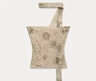 Top color crema con bordado de flores en negro, de breteles finos y corte ajustado.