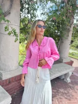 Camisa rosa de lino, de corte crop y mangas largas con puños elásticos.