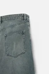 Pantalón de jean negro de corte amplio, con cinco bolsillos, efecto lavado y cierre frontal con cremallera y botón.