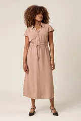 Vestido camisero color beige con cuello, botones frontales, mangas cortas y lazo ajustable en la cintura.