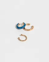 Set de tres earcuffs dorados, uno esmaltado en azul y otro con diseño torzado.