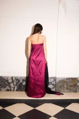 Vestido strapless de tafeta color magenta y negro, con corte holgado, largo midi, bolsillos laterales y pieza bicolor desmontable.