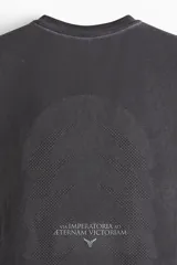 Musculosa deportiva negra con cuello redondo, corte entallado y espalda deportiva. Presenta detalles reflectantes en el pecho y la espalda, y paneles de malla en los laterales.