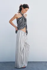 Pantalón palazzo de algodón color crudo con rayas verticales azules, tiro medio, cintura ajustable con cordones, bolsillos laterales ocultos y pierna recta.