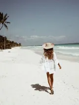 Vestido playero blanco con mangas largas, escote en V y detalles de encaje calado.