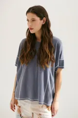 Remera azul de corte holgado con mangas cortas y costuras a la vista en color blanco.