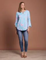 Blusa de seda fría estampada con flores en tonos celeste y rosa, marca Ruby Rd. Tiene cuello redondo con escote en V entrelazado y mangas 3/4 acampanadas.