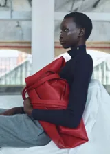 Bolso tote de cuero color rojo con doble asa de mano y cierre con lazo.